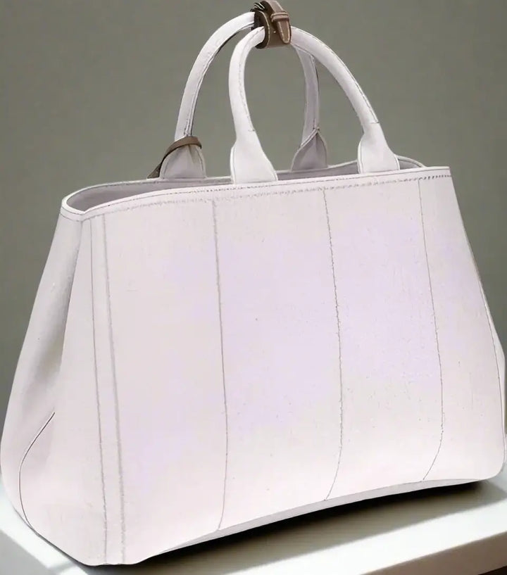 Light gray handbag with a strap on a white background