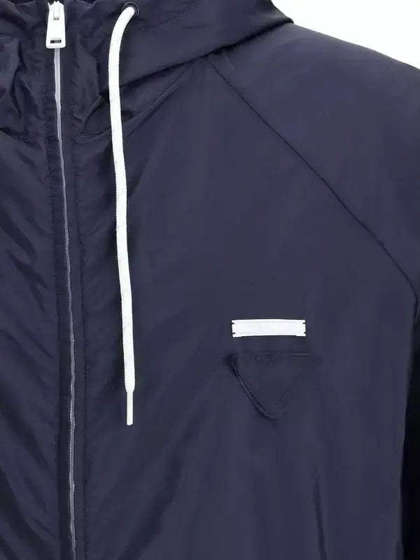 Navy blue raincoat with white zipper and pocket on a white background