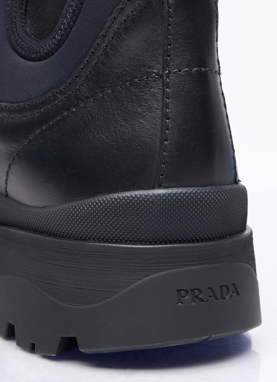 Close-up of a black Prada boot sole on a white background