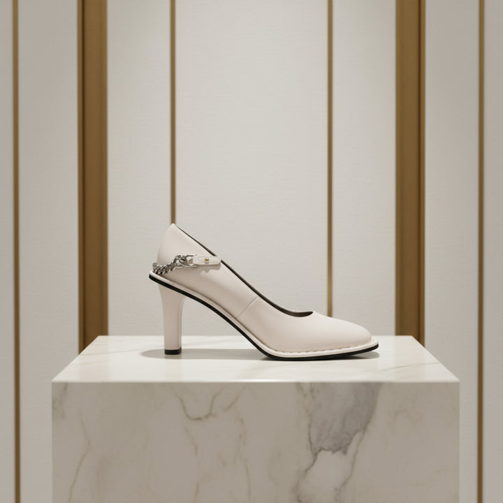 White high-heeled shoe with a decorative chain on a white background