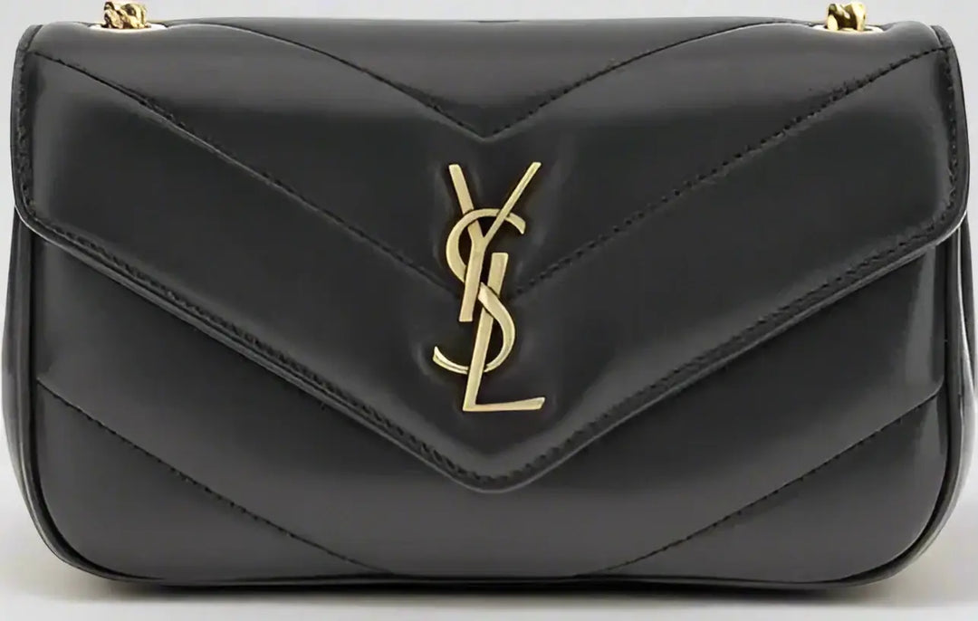 Black handbag with a gold logo on a black background