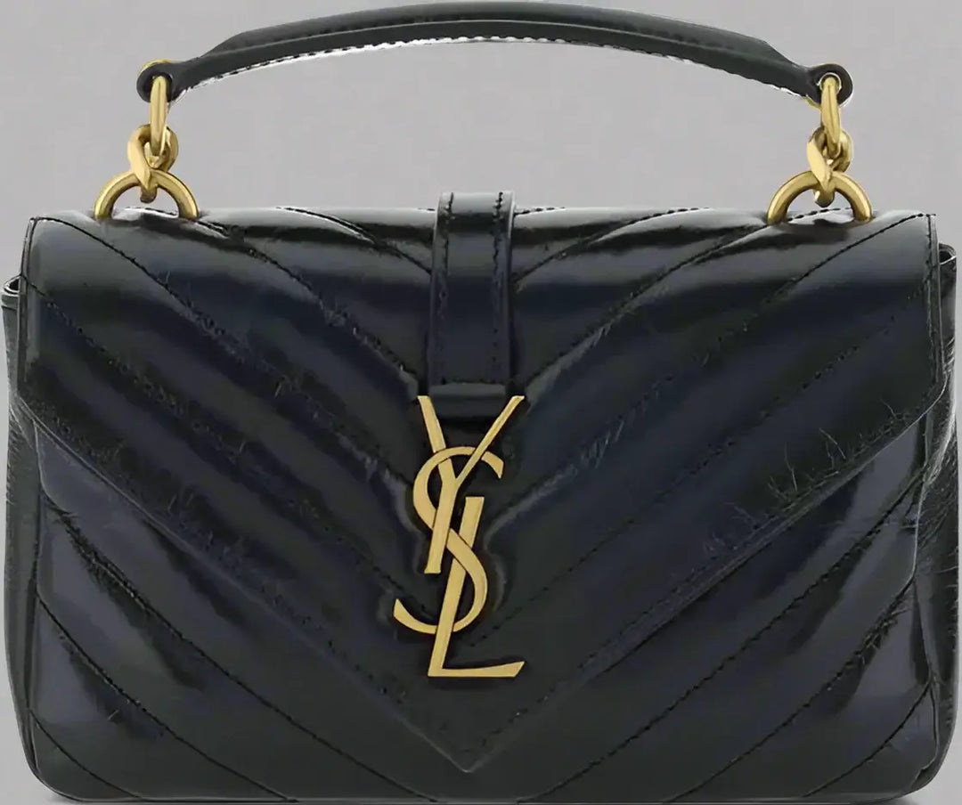 Black quilted handbag with gold accents and logo on a white background