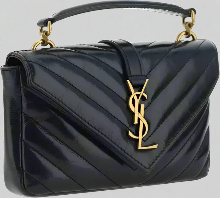 Black quilted handbag with gold logo on a white background
