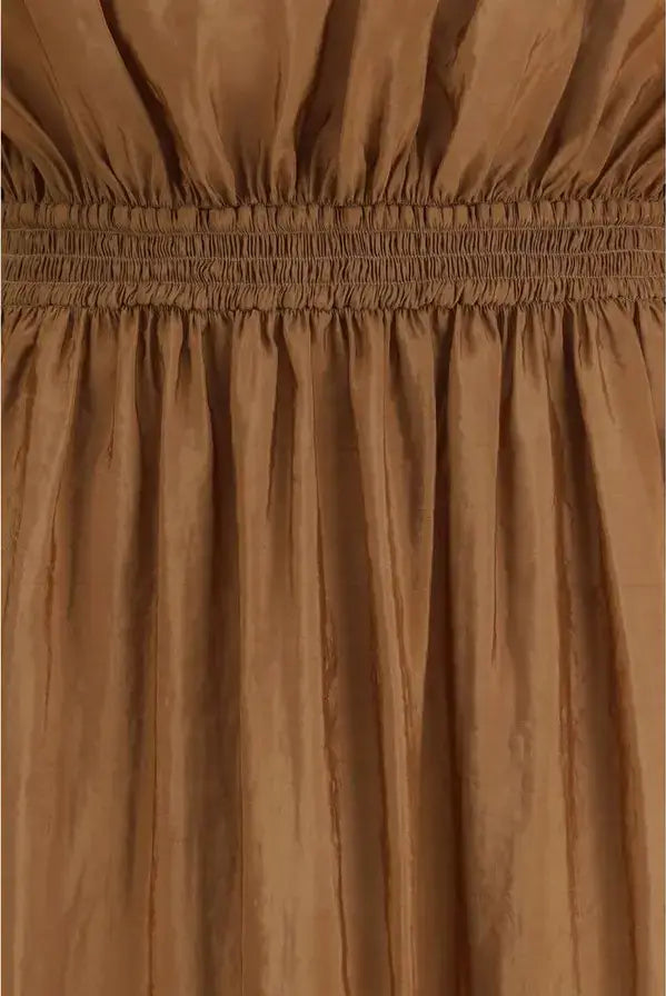 Close-up of a brown dress with a smocked waistband