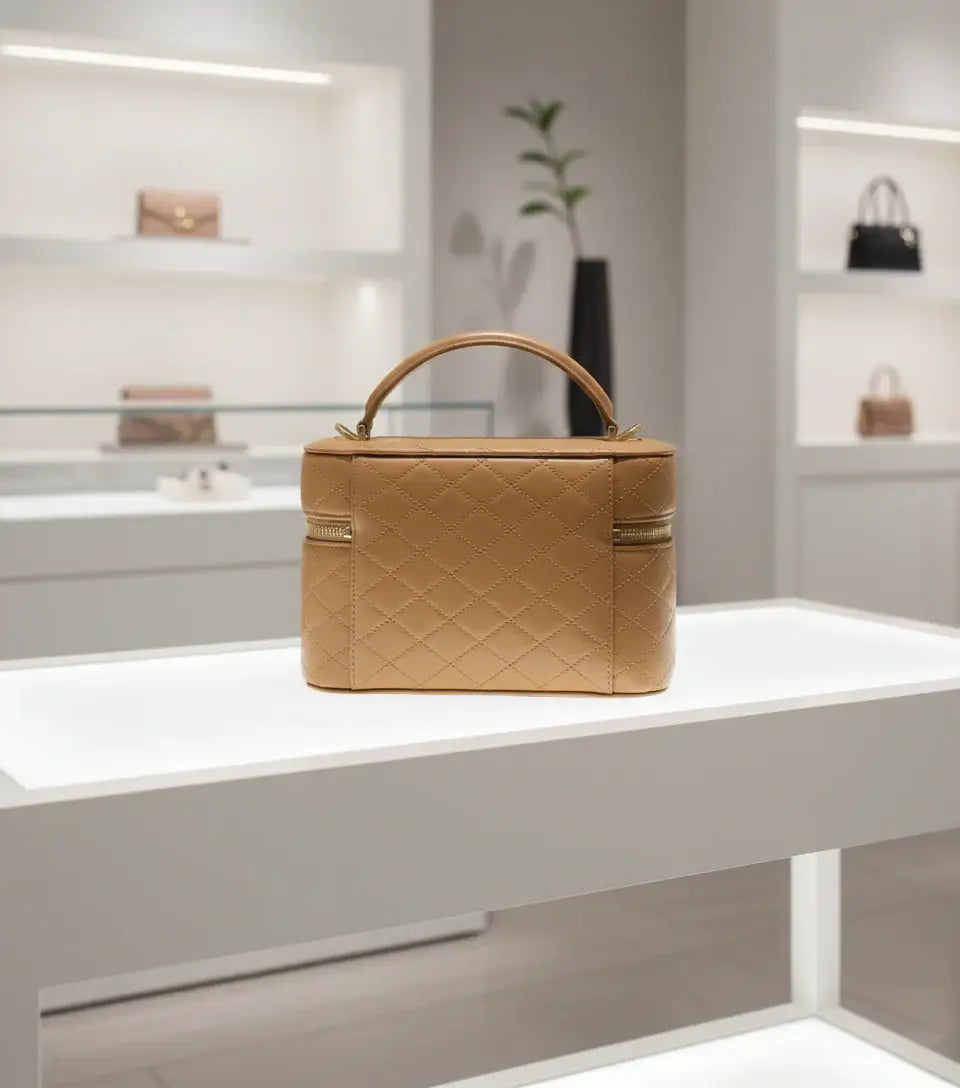 Quilted beige handbag with gold zipper on a white background