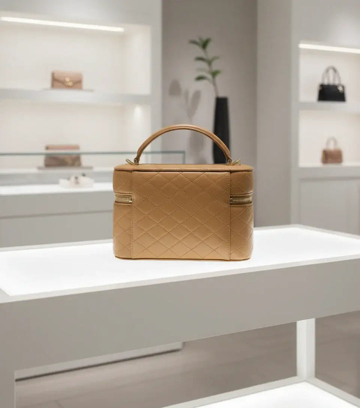 Quilted beige handbag with gold zipper on a white background