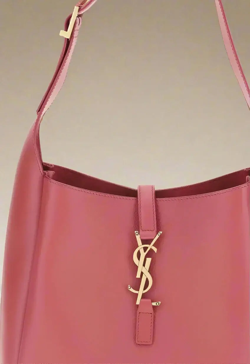 Pink handbag with a gold logo on a white background