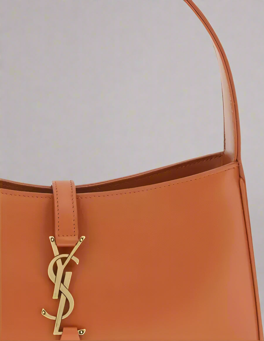 Brown handbag with a gold logo on a white background