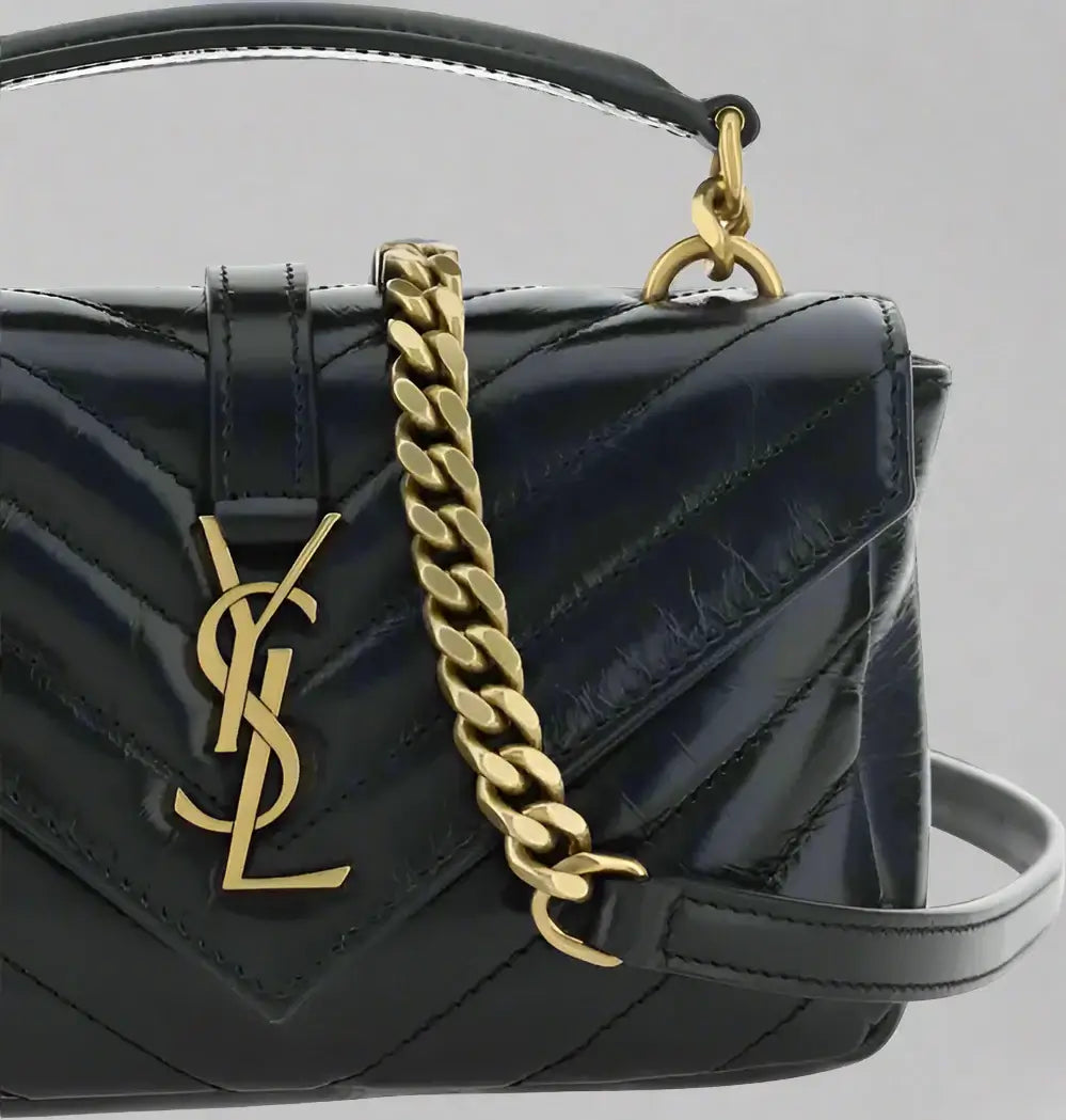 Black quilted handbag with gold chain strap and logo on a white background