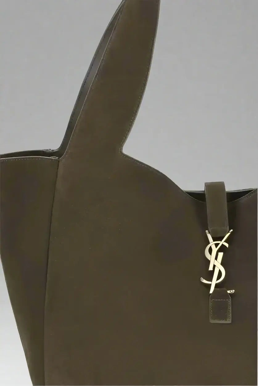 Brown handbag with a gold logo tag on a white background