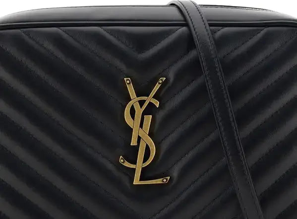 Black quilted handbag with gold logo on a black background