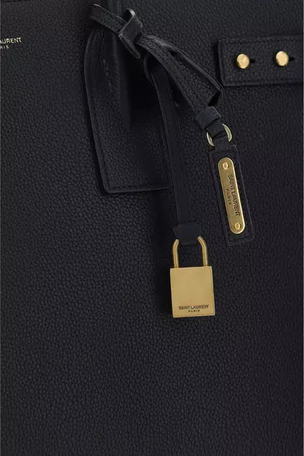 Black textured bag with a gold padlock and strap detail, featuring the Saint Laurent logo.