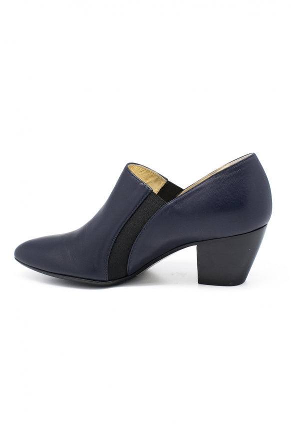 Navy blue shoe with a black strap on a white background