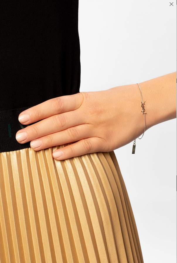 Hand wearing a bracelet on a plain background