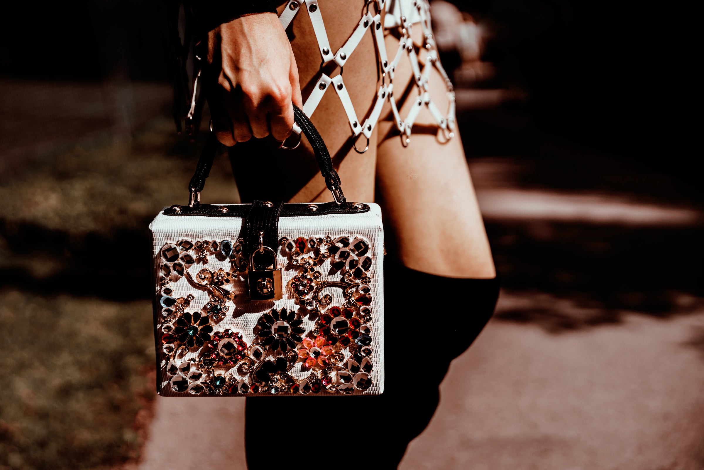 Woman in designer skirt and holding white box purse