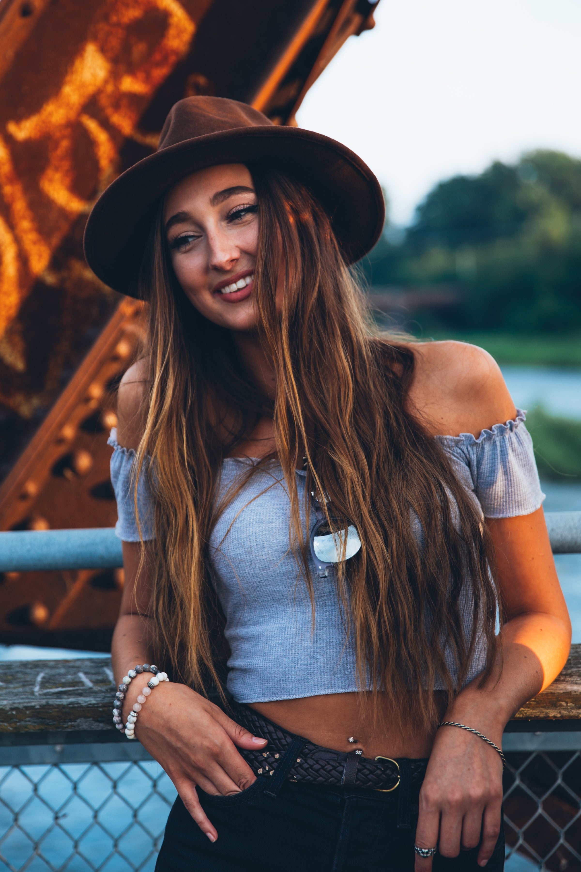 Woman in hat leaning on fence