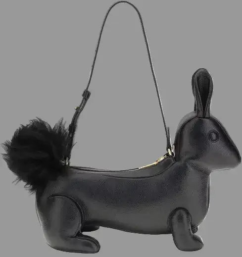 Black dachshund-shaped handbag with a fluffy tail on a white background