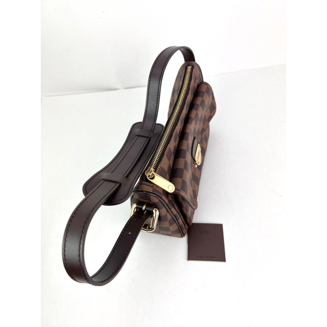 Brown checkered handbag with black strap on a white background