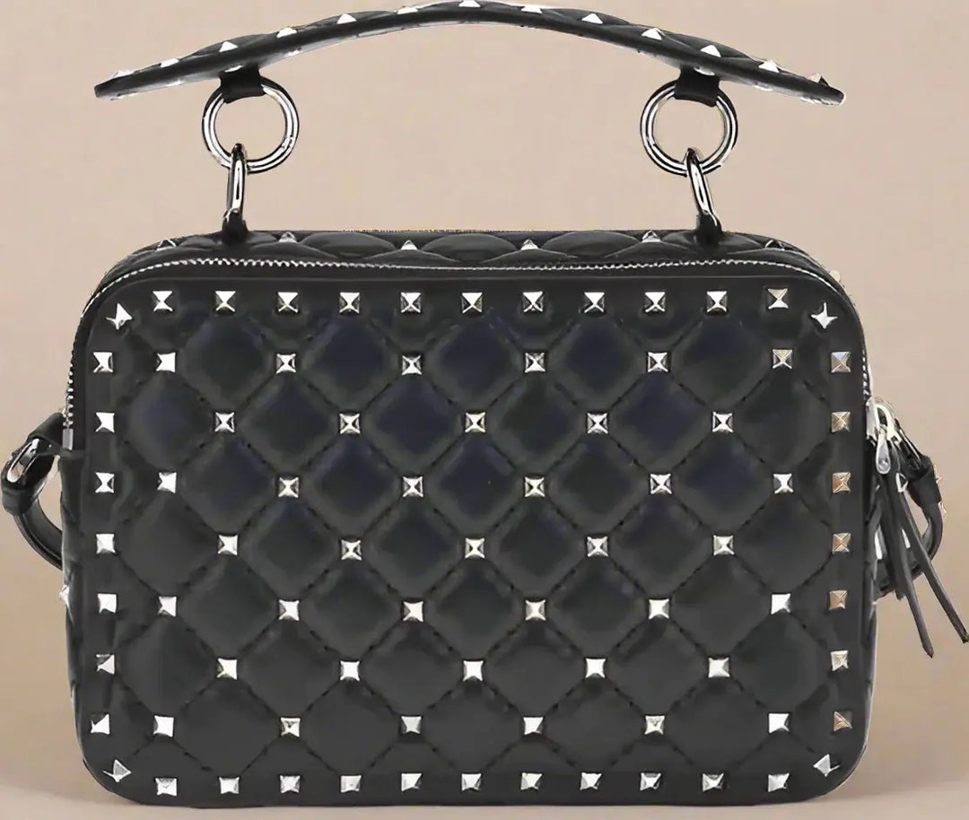 Black quilted handbag with silver studs on a white background