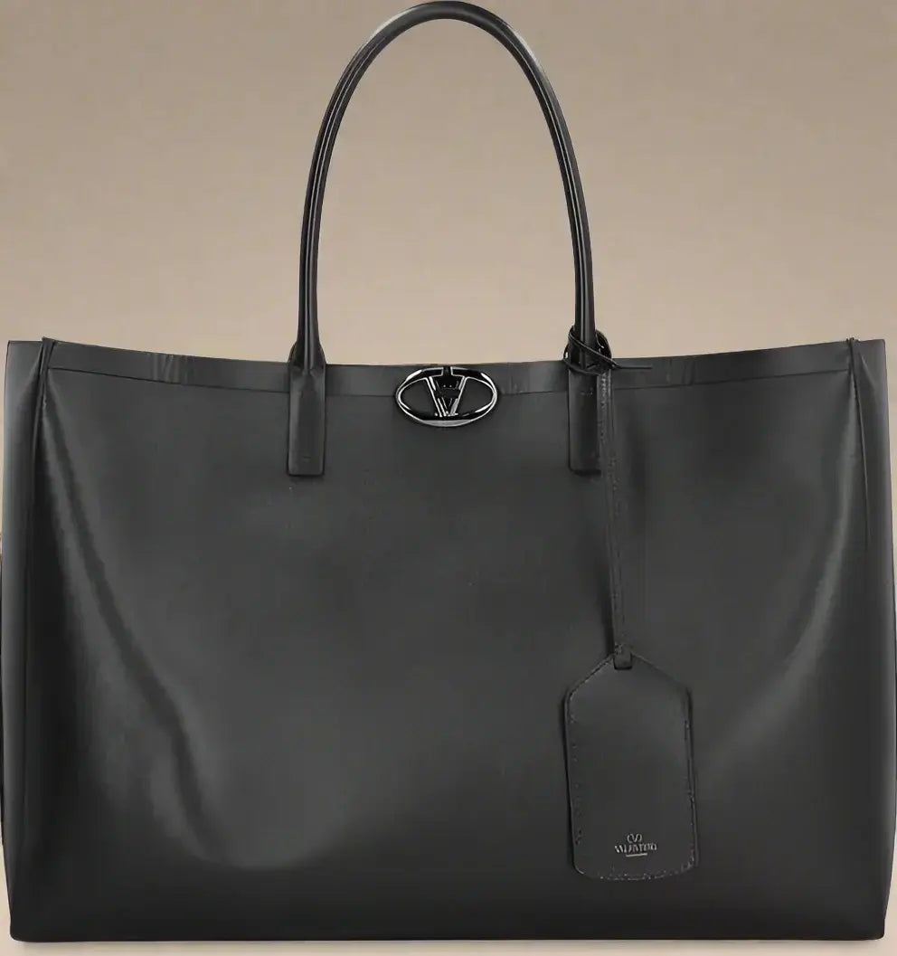 Black leather tote bag with a brand logo on a white background