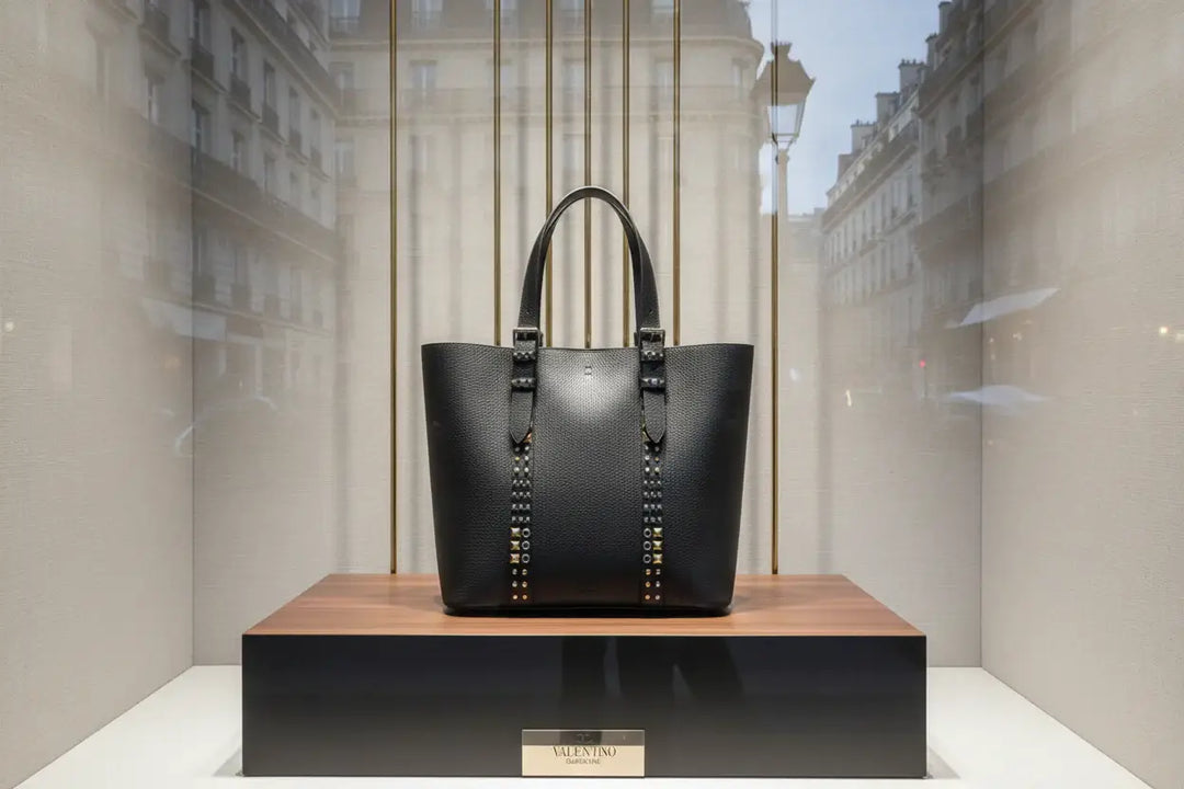 Black tote bag with studded details on a white background