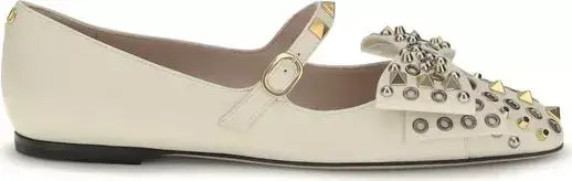 White flat shoe with embellishments on a white background