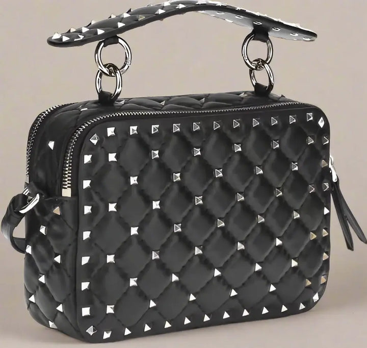 Black quilted handbag with silver studs on a white background