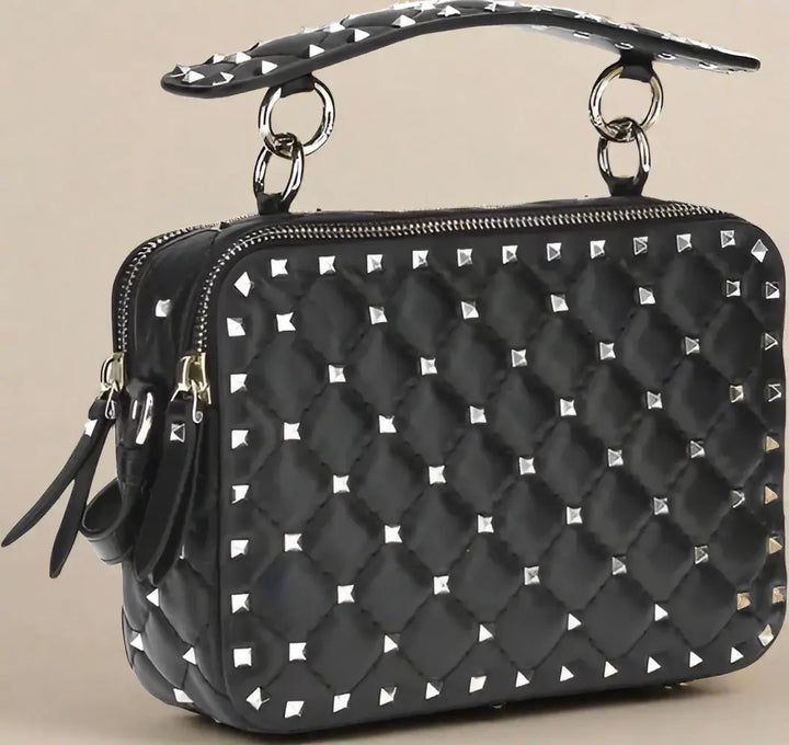 Black quilted handbag with silver studs on a white background