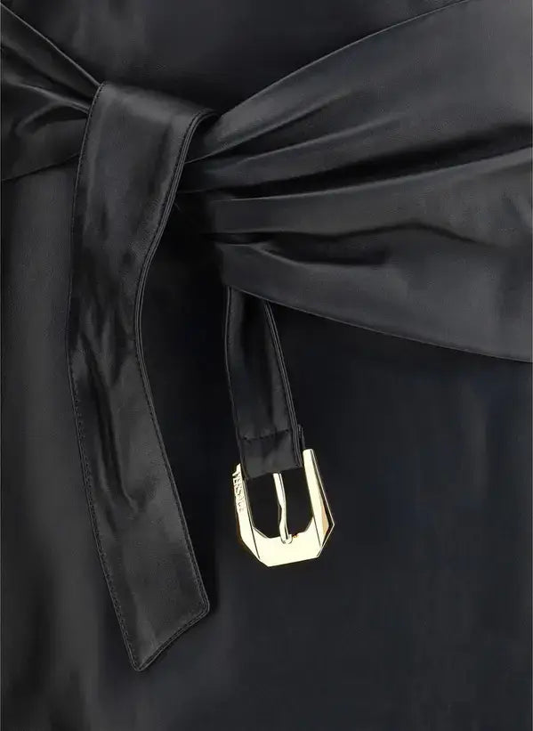 Black satin garment with a gold buckle on a dark background