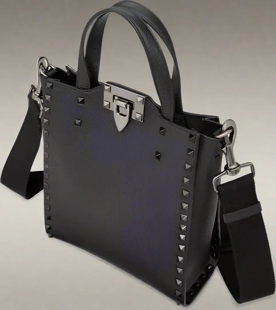 Black handbag with studded details and a shoulder strap on a white background