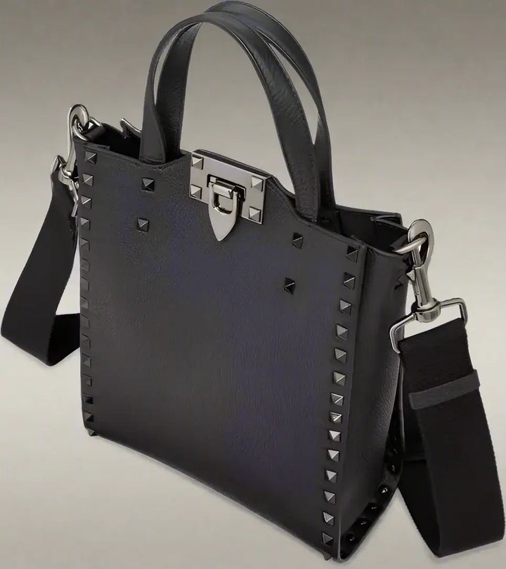 Black handbag with studded details and a shoulder strap on a white background
