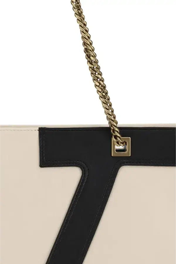 Close-up of a handbag with a gold chain strap on a white background
