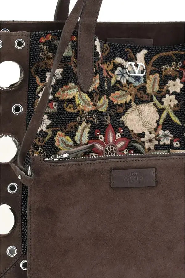 Brown handbag with floral embroidery and decorative studs