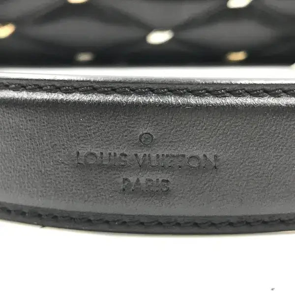 Close-up of a black leather belt with Louis Vuitton branding.