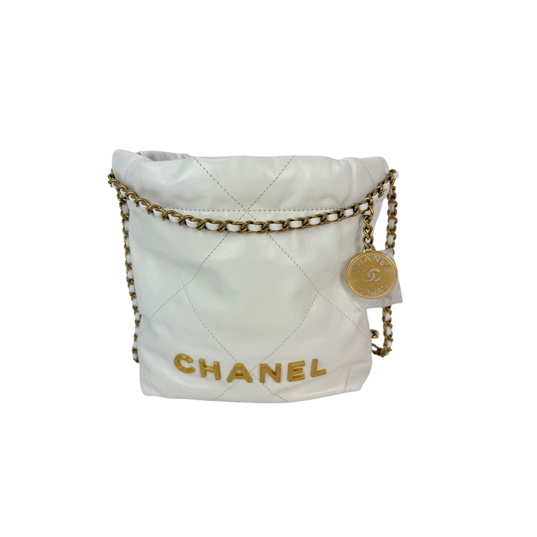 White quilted Chanel bag with gold chain on a white background