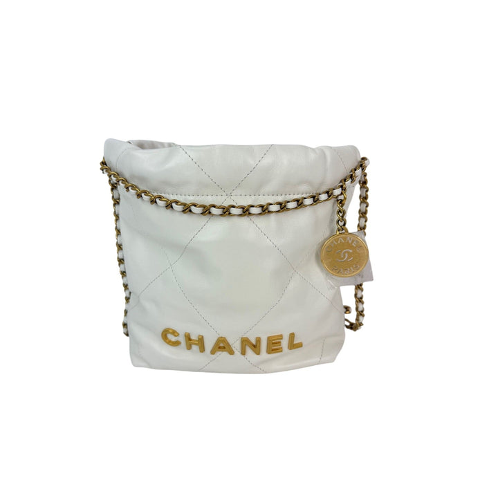 White quilted Chanel bag with gold chain on a white background