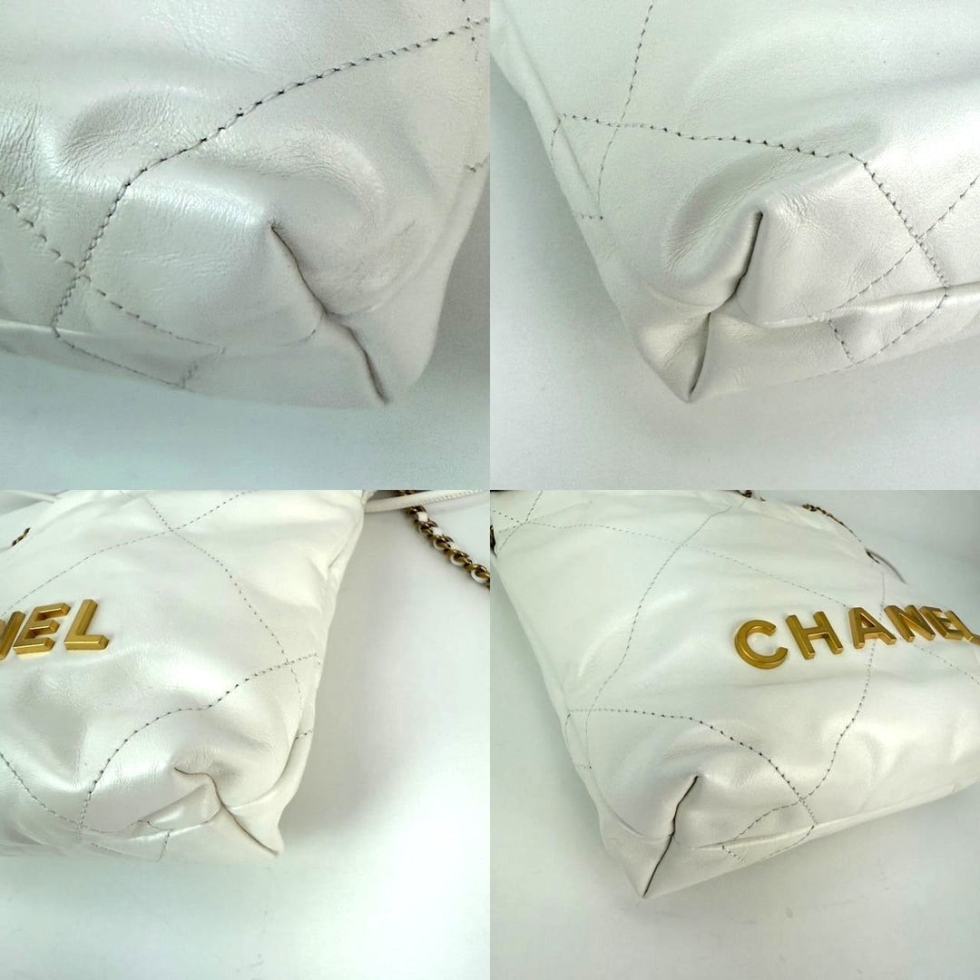 Close-up of a quilted white handbag with gold 'Chanel' branding on a light gray background.