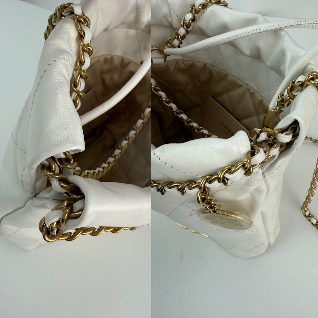 Close-up of a white handbag with gold chain detail on a light gray background