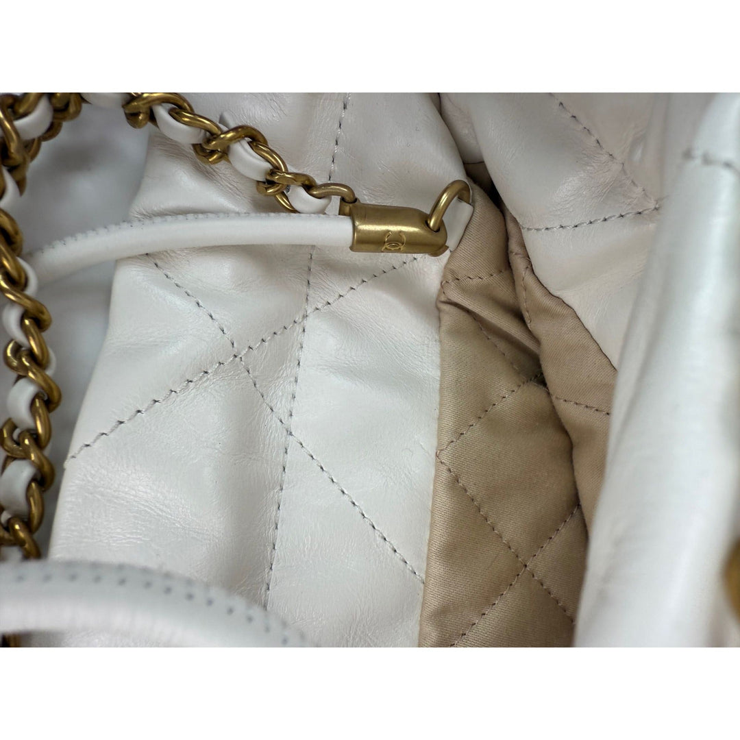 Close-up of a white quilted handbag with gold chain handle