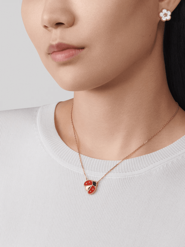 Van Cleef & Arpels Lucky Spring pendant, open wings ladybug 18K rose gold, Carnelian, Onyx worn by a woman.