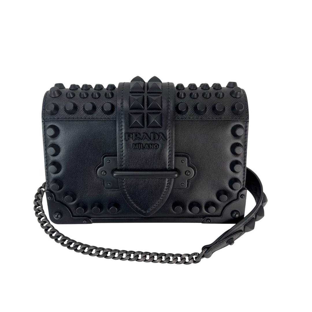 Black studded handbag with chain detail on a white background