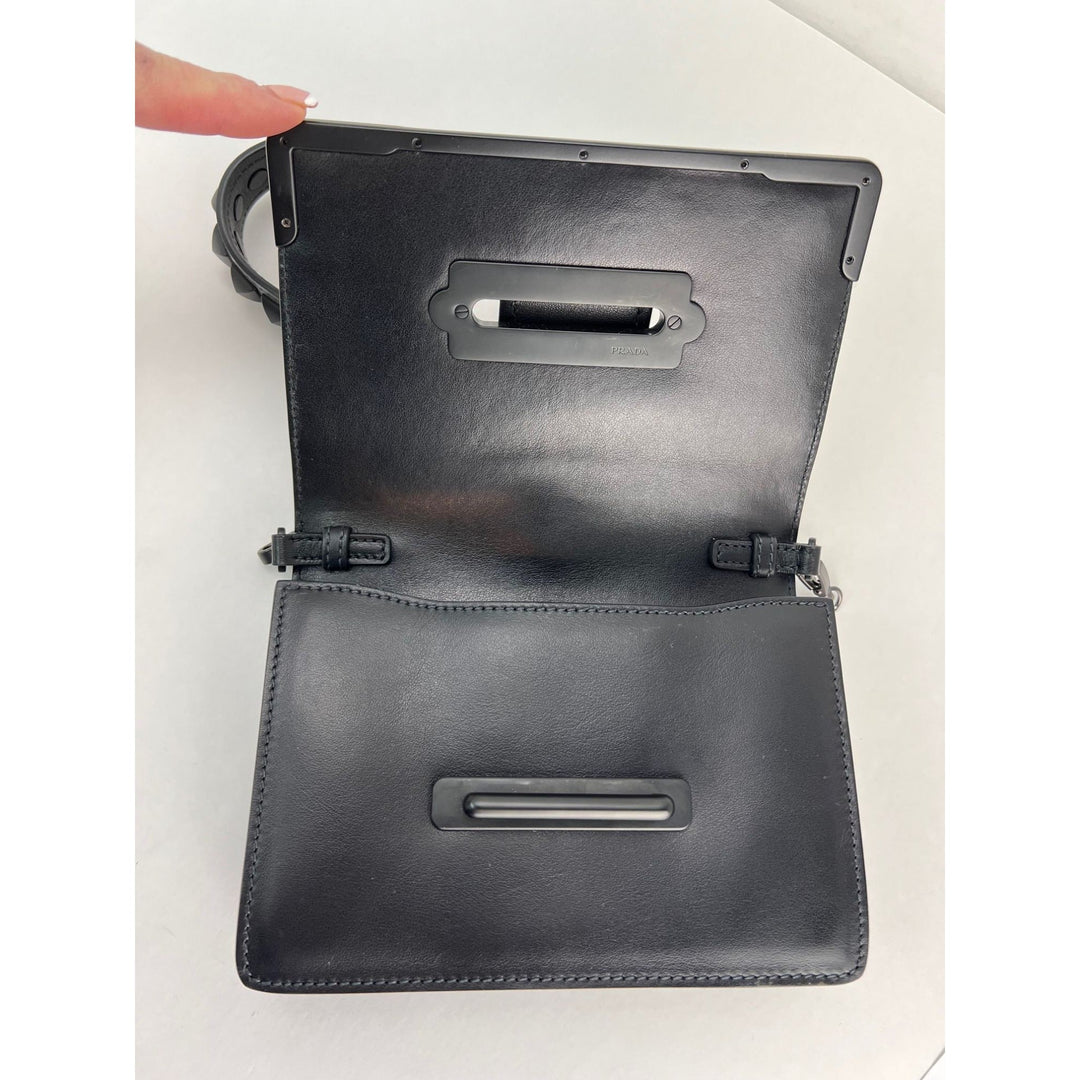 Black leather clutch bag with a handle on a white background