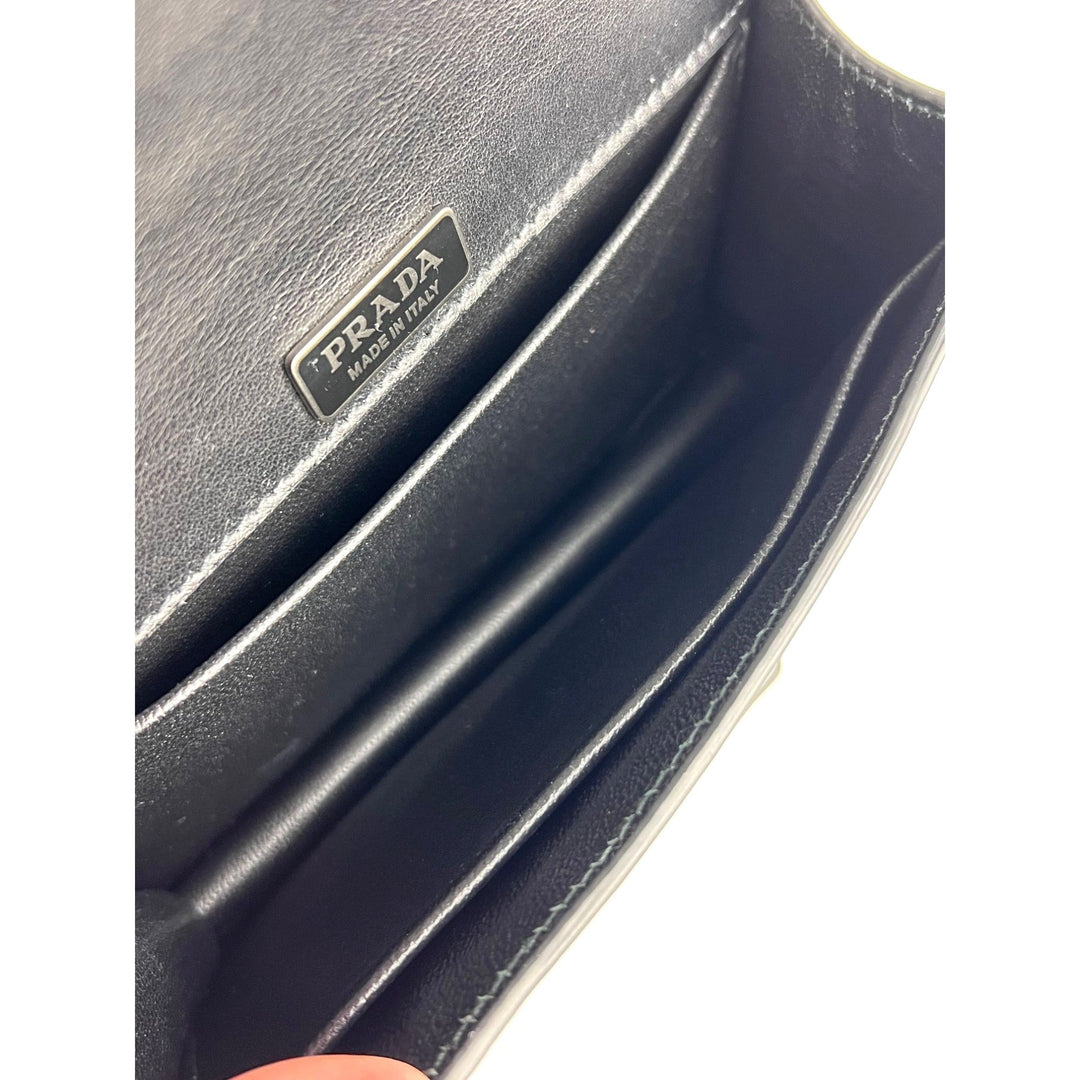 Close-up of a Prada wallet with a visible brand logo.