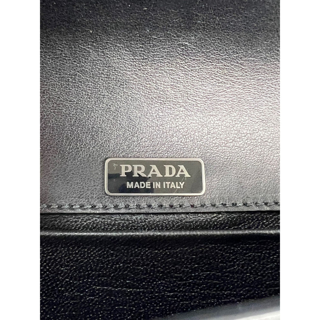 Black Prada wallet with 'Made in Italy' label on a white background
