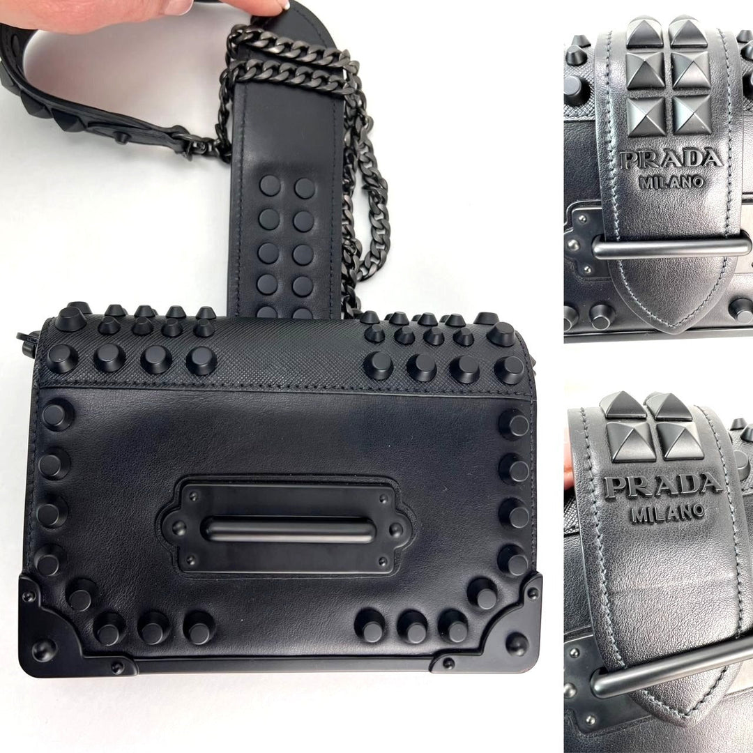 Black studded handbag with Prada branding on a white background