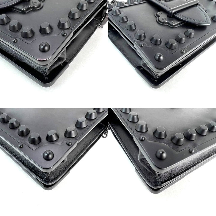 Black leather wallet with textured surface and metal clasp on a white background
