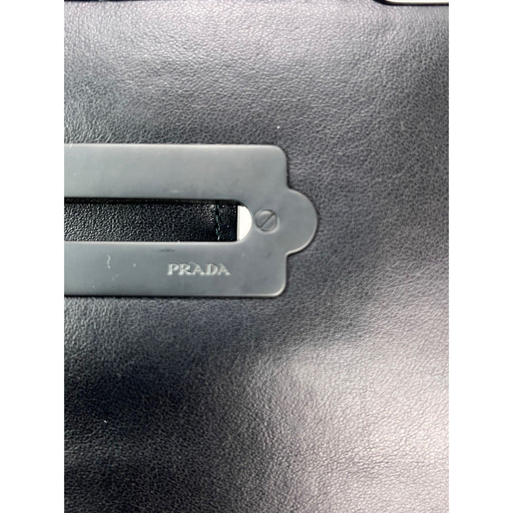 Close-up of a Prada logo on a black leather surface